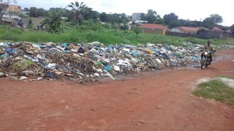 A boda boda rider passes on the road with mixed wastes inclusive of medical waste along roads in Abuga sub count